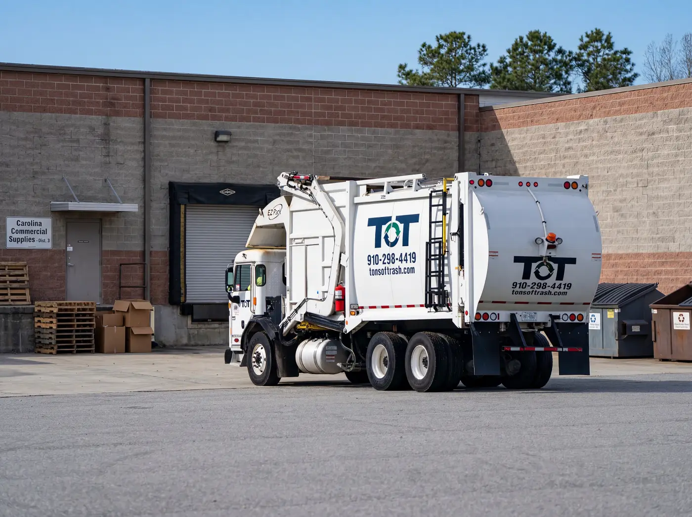 Commercial dumpster being serviced by Tons of Trash